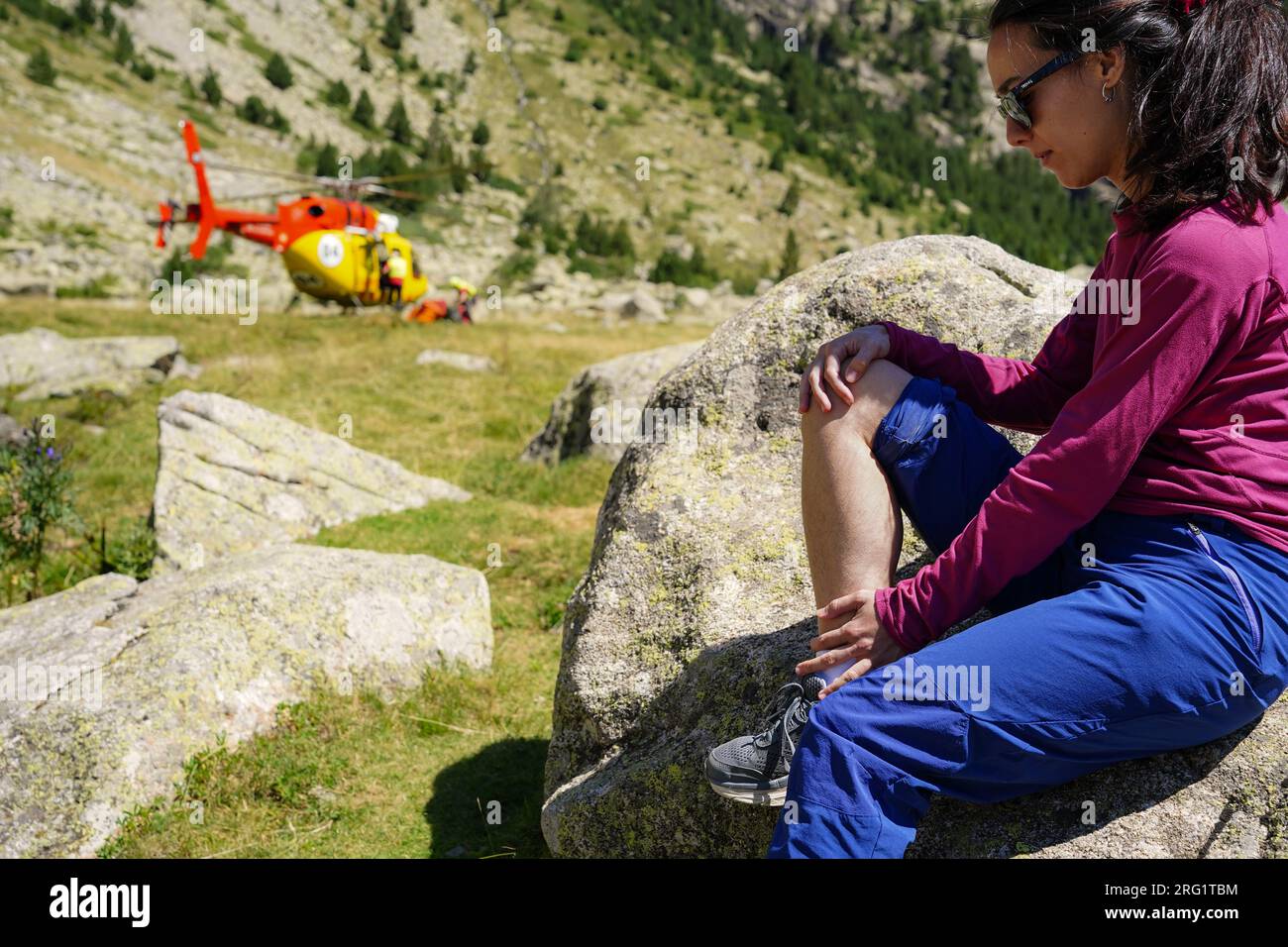 Pompiers hélicoptère de sauvetage de montagne vole en cas d'urgence. Assistance à une entorse de femme Banque D'Images