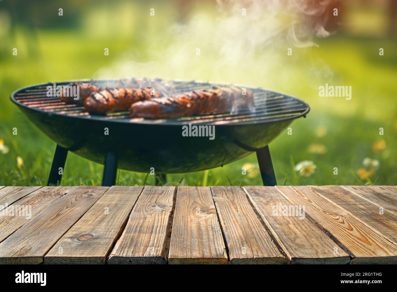 L'été dans le jardin de l'arrière-cour avec barbecue, table en bois, arrière-plan flou Banque D'Images