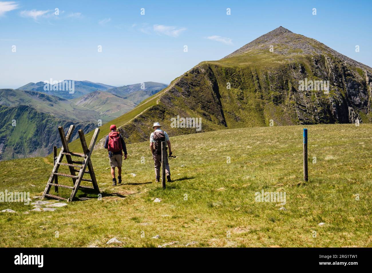 Deux randonneurs marchant sur Marchlyn Horseshoe avec Elidir Fawr montagne devant dans Snowdonia Nation Park (Eryri). Bethesda, Gwynedd, nord du pays de Galles, Royaume-Uni, Grande-Bretagne Banque D'Images