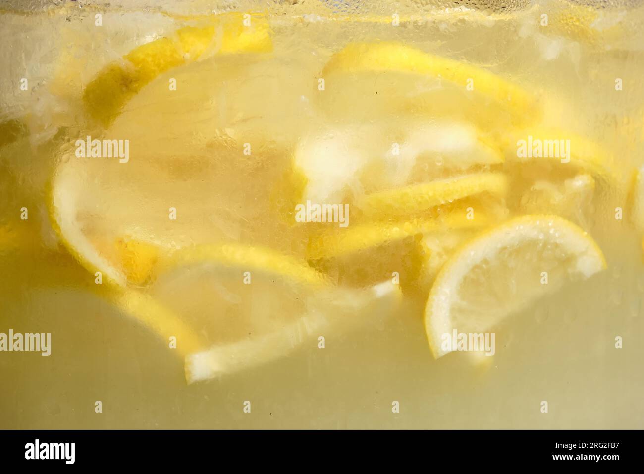 gros plan de tranches de citron flottant dans un pot transparent de limonade Banque D'Images