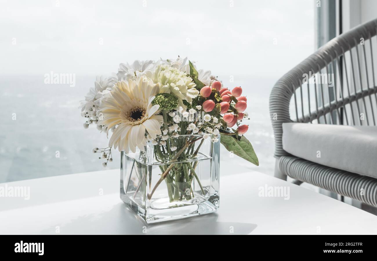 Beau bouquet blanc de fleurs en vase sur la table du bateau de croisière. Banque D'Images