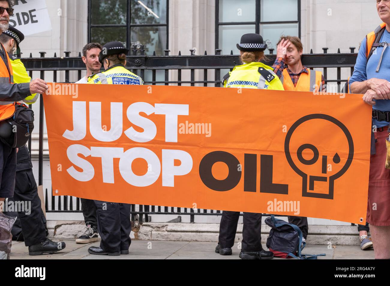 Just Stop Oil militants sont détenus par la police à Londres, faisant campagne pour que le gouvernement arrête toute licence et production future de combustibles fossiles. Banque D'Images