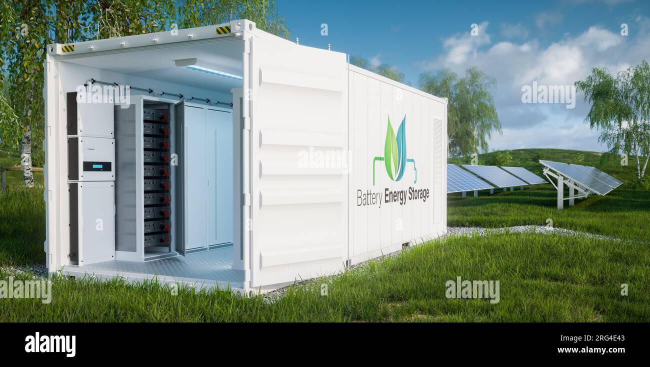 Vue rapprochée des modules de batterie pour le stockage d'énergie à l'intérieur d'un conteneur industriel ouvert sur une pelouse luxuriante avec une centrale photovoltaïque dans le backgro Banque D'Images