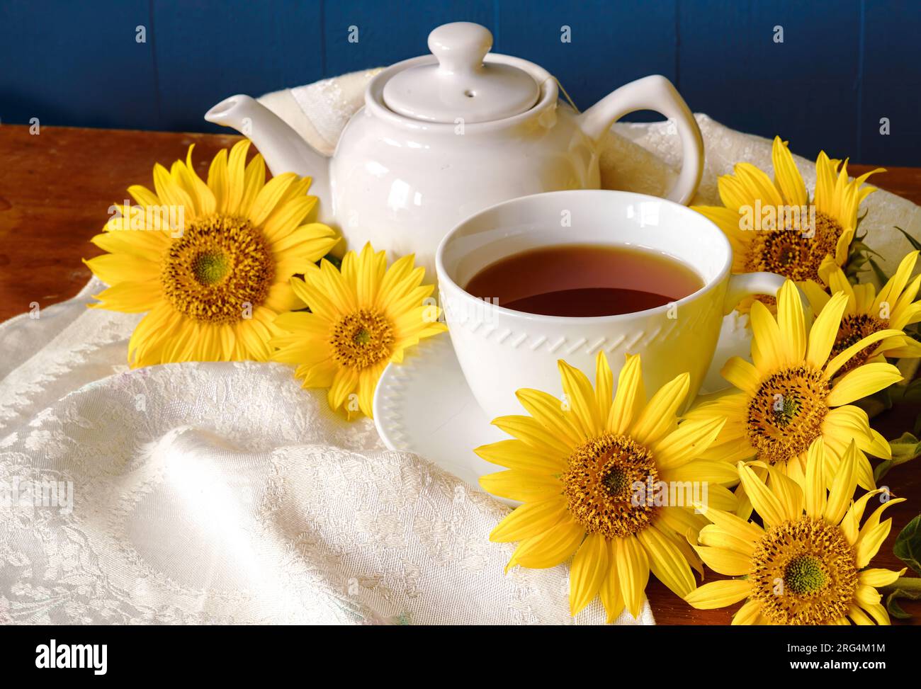 Tasse à thé et théière sur un fond rustique avec des tournesols. Banque D'Images