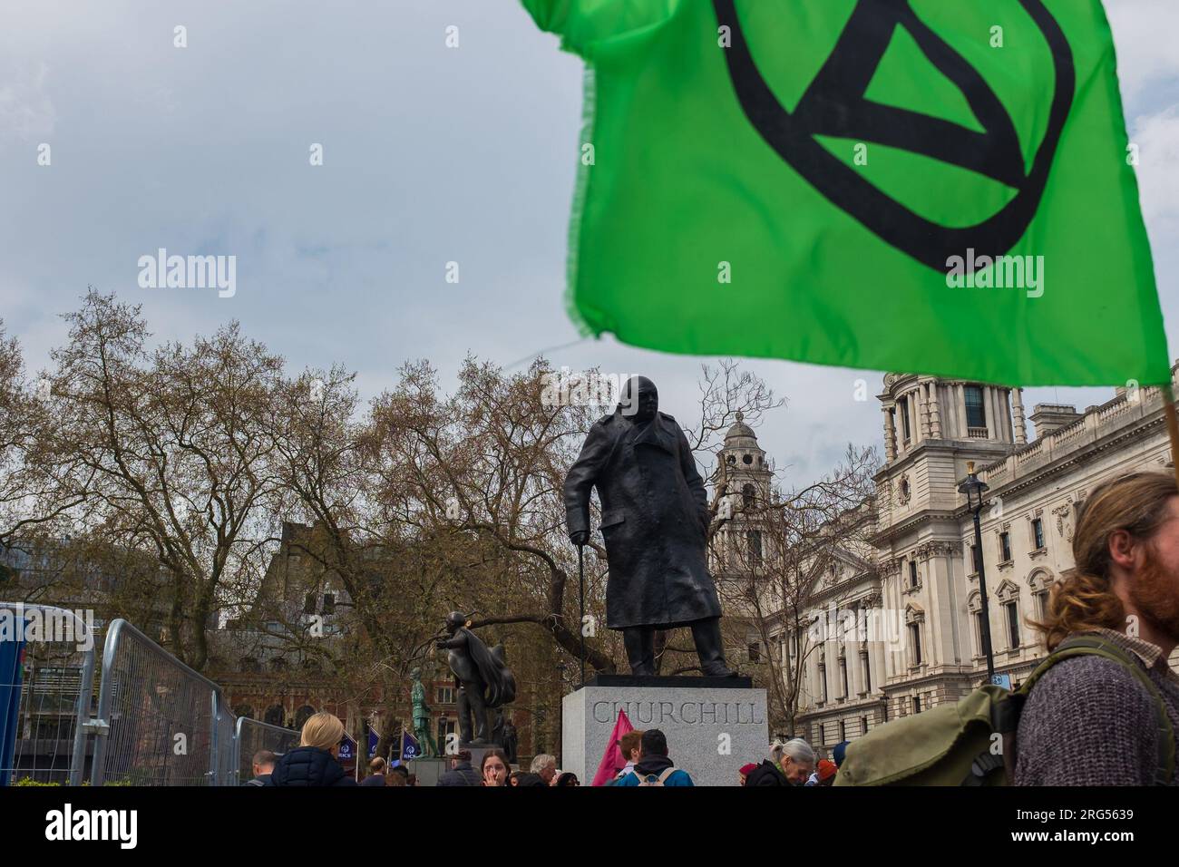 Londres, Royaume-Uni, 2023. Drapeau vert avec le symbole de l'extinction rébellion sur la place du Parlement, avec la statue de Churchill en arrière-plan Banque D'Images