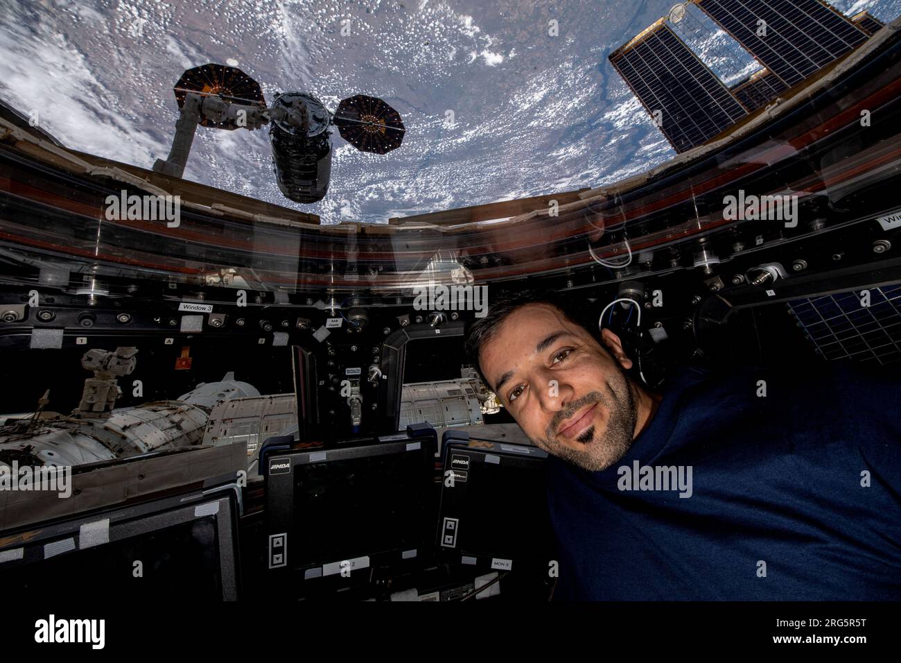 Station spatiale internationale, ORBITE TERRESTRE. 04 août 2023. Sultan Al Neyadi, astronaute et ingénieur de vol de l'expédition 69 des Émirats arabes Unis, pose à l'intérieur de la coupole de la Station spatiale internationale avec le vaisseau spatial Cygnus NG-19 Cargo à l'extérieur de la fenêtre, le 4 août 2023 en orbite terrestre. Crédit : NASA/NASA/Alamy Live News Banque D'Images