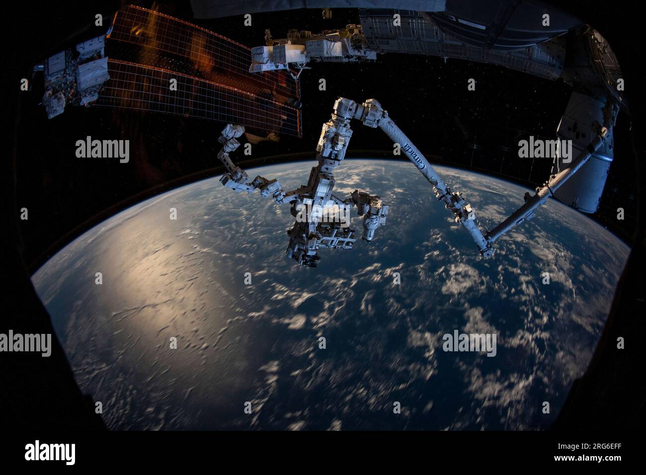 Le bras robotique Canadarm2 avec la main robotique Dextre attachée dépasse de la Station spatiale internationale. Banque D'Images