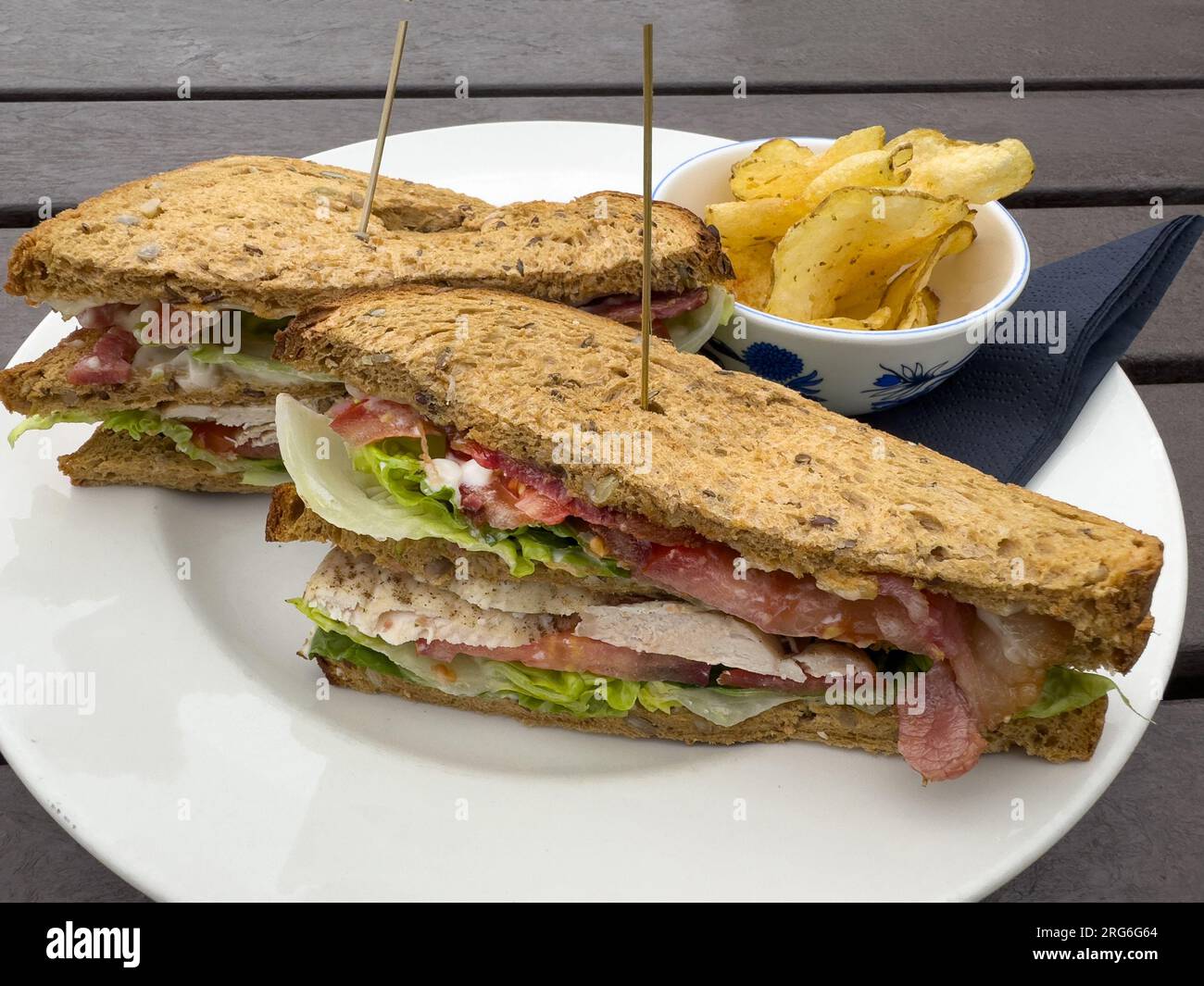 Club sandwich à base de poulet, jambon tomate et salade avec chips de pommes de terre Banque D'Images