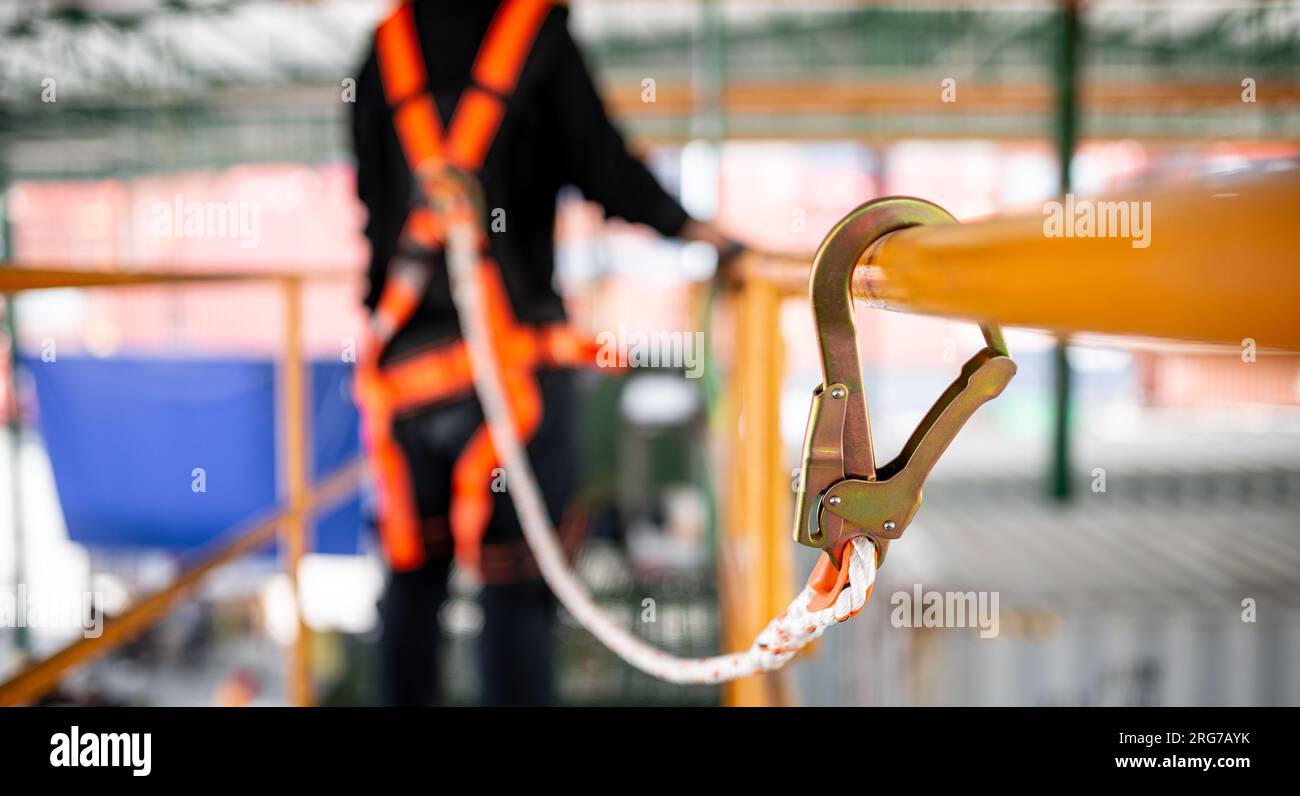 Travailleur de la construction portant un harnais de sécurité et une ligne de sécurité travaillant à endroit élevé Banque D'Images