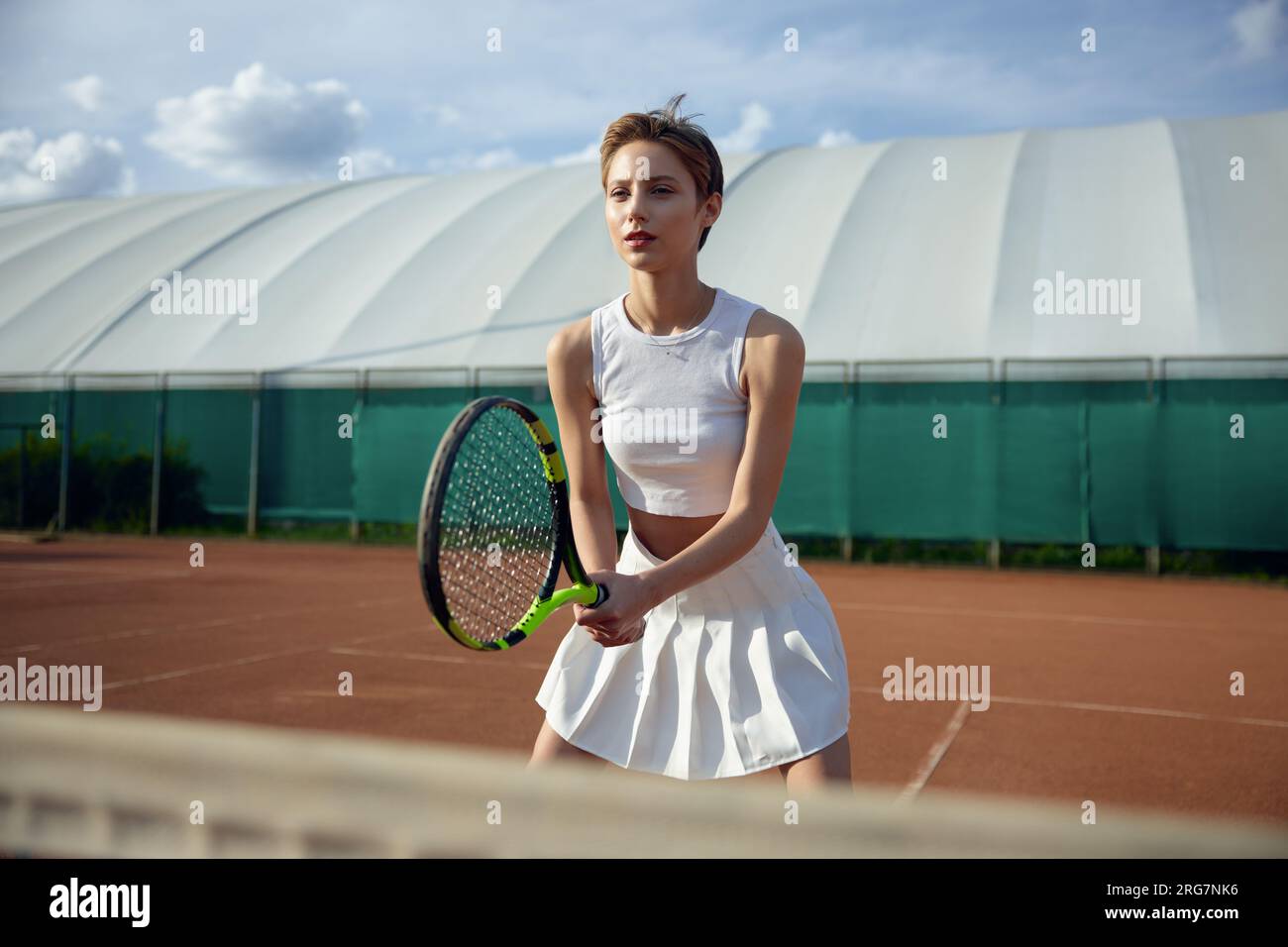 Vue de face d'une joueuse de tennis de confiance tenant une raquette Banque D'Images