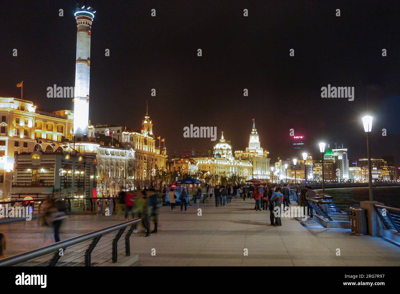 Shanghai, Chine - 29 mars 2011: Les gens marchent le long de la promenade de Shanghai appelée le Bund par nuit. Les anciens bâtiments historiques sont éclairés. Banque D'Images