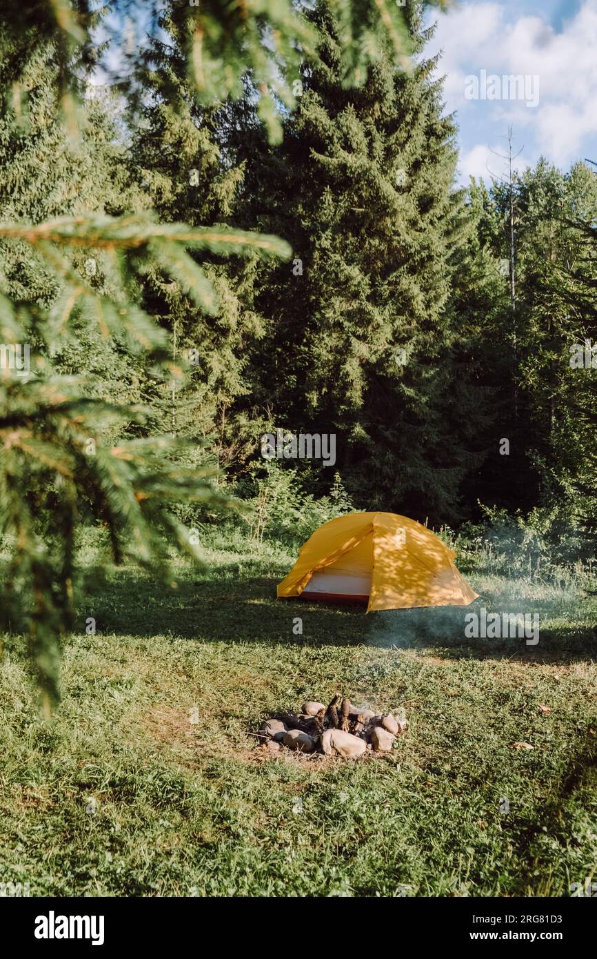 Inspiration Images d'un feu de camp et d'une tente de camping près d'une magnifique forêt verdoyante majestueuse le matin d'été. Voyage, concept d'aventure Wanderlust, Banque D'Images