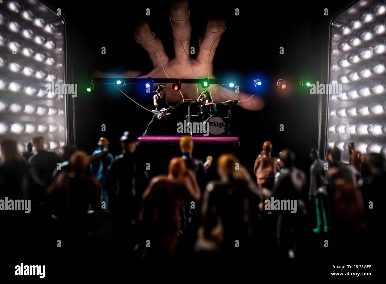 Groupe de heavy Metal miniature se produisant devant des personnes miniatures dans le public dans un environnement de club à la mémoire du bassiste Cliff Burton, Master of Puppets Banque D'Images