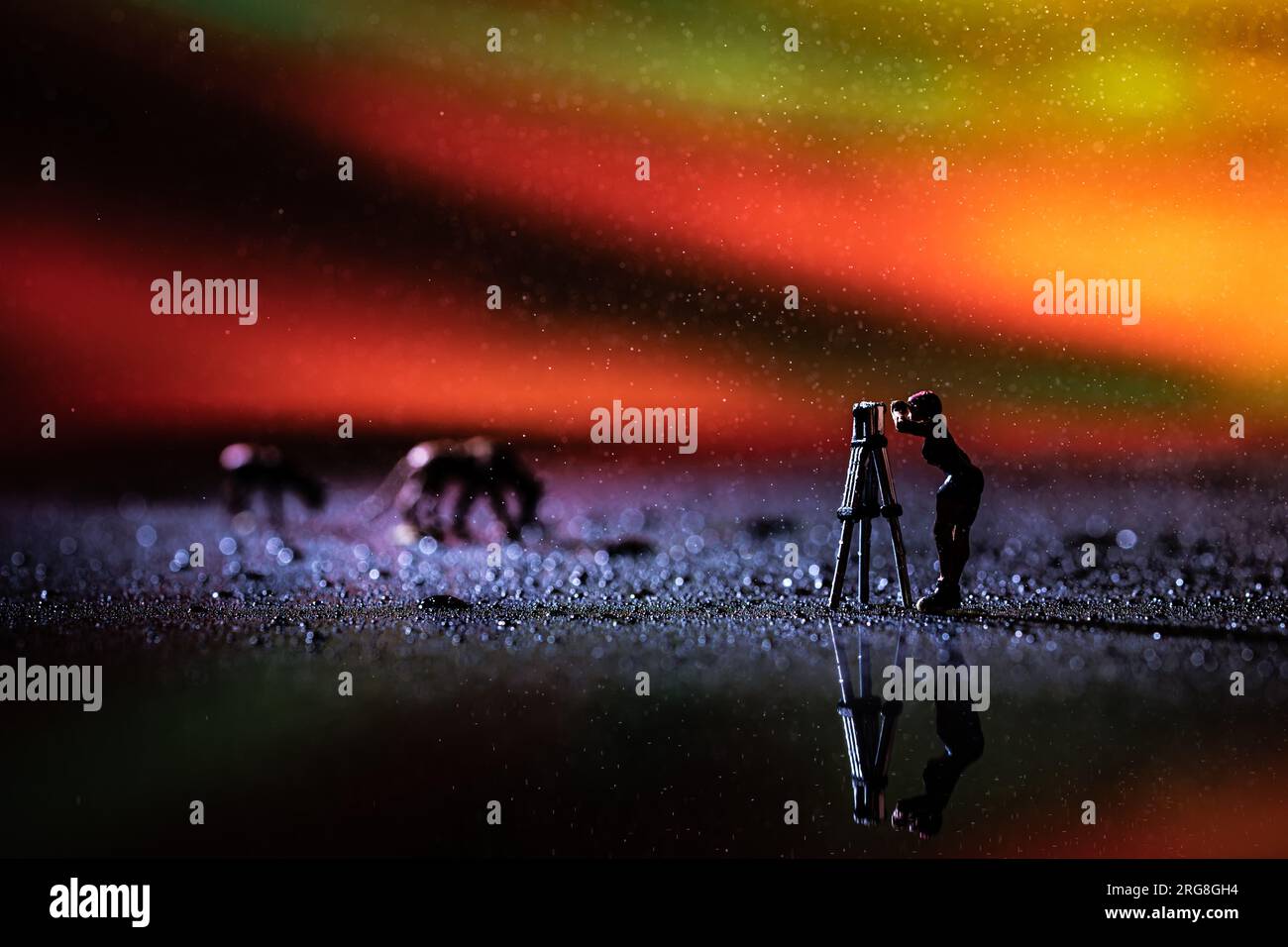 Photographe miniature en action avec un fond d'aurore simulé. Aurora (PL : aurorae ou auroras), également connue sous le nom de lumières polaires, li du nord Banque D'Images