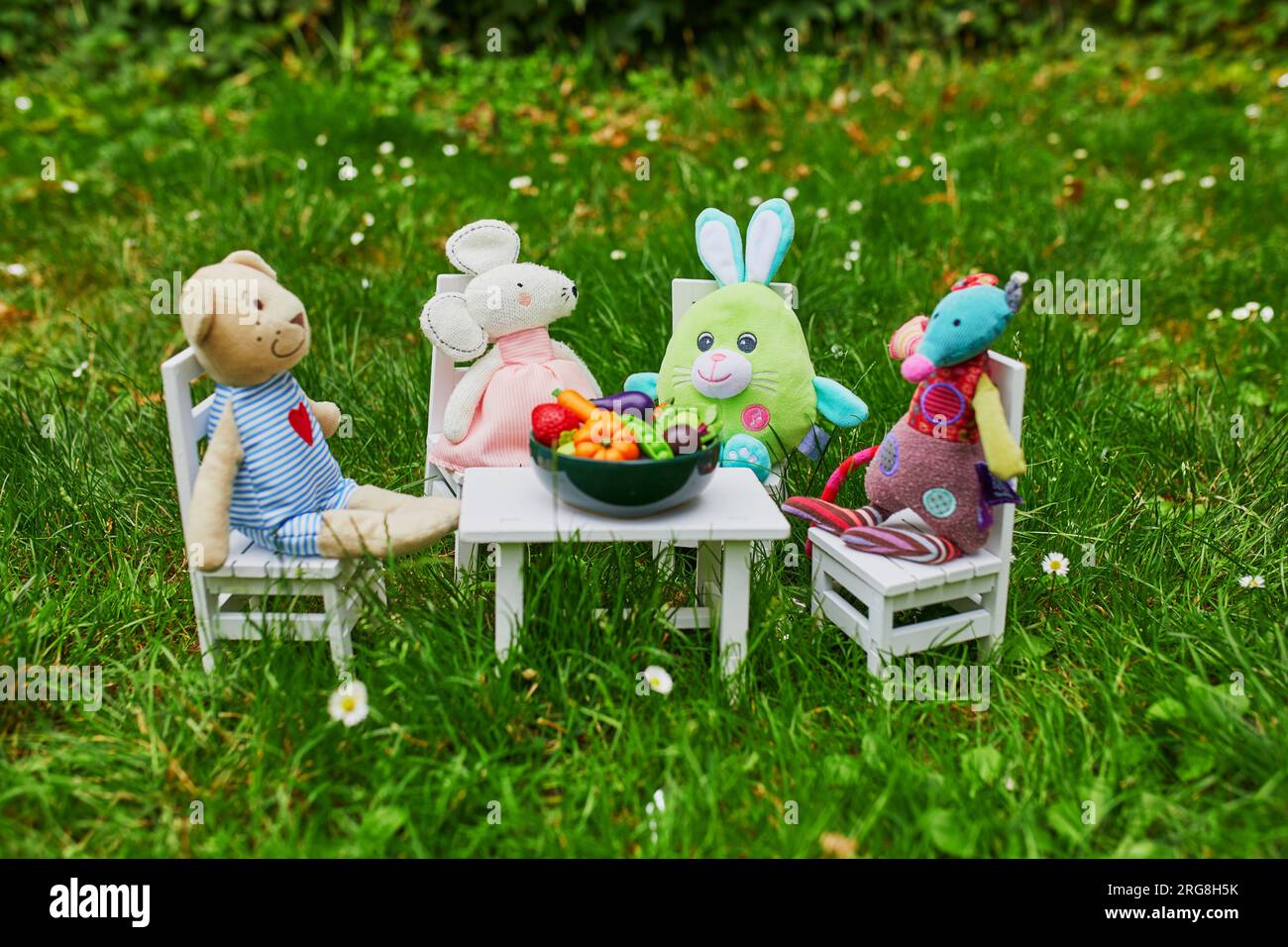 Peluches ayant un dîner avec des figurines d'argile de fruits et légumes. Jeux de rôle pour les petits enfants Banque D'Images