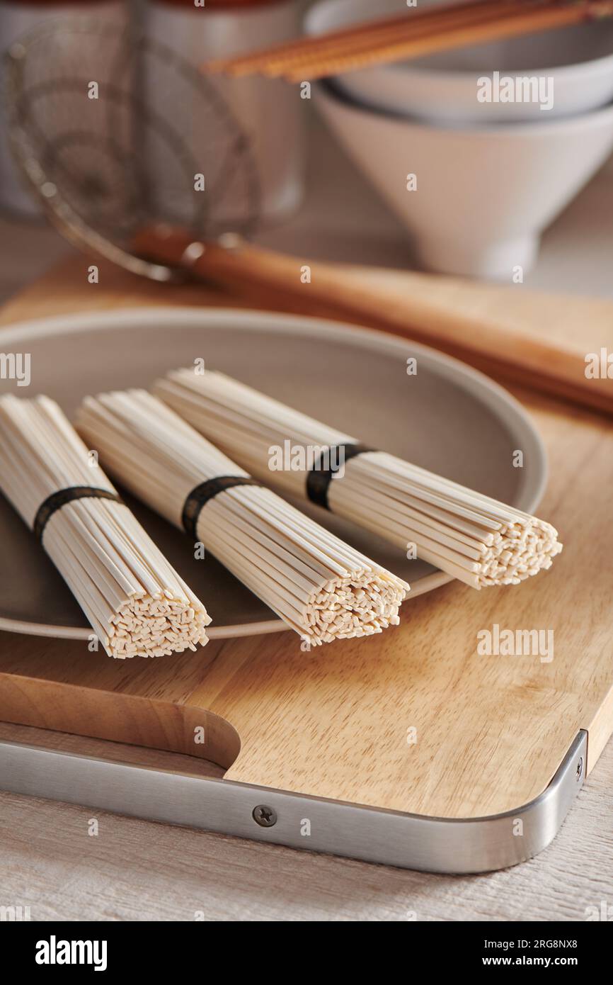 Nouilles udon de blé crues sur l'assiette, cuisine orientale et asiatique Banque D'Images