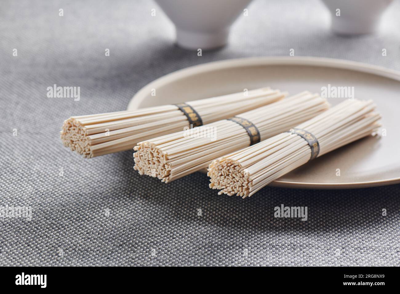Nouilles udon de blé crues sur l'assiette, cuisine orientale et asiatique Banque D'Images