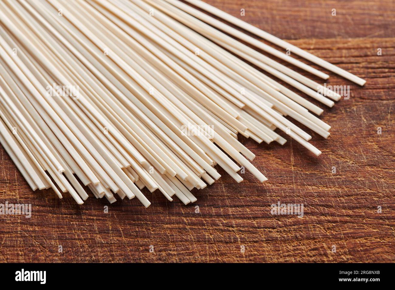 Pile de nouilles udon de blé non cuites sur planche à découper, cuisine orientale et asiatique Banque D'Images