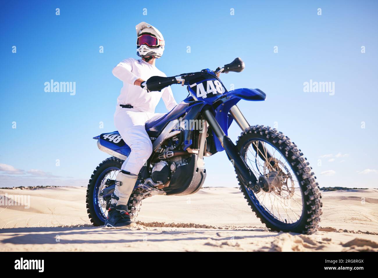 Sable, sports motorisés et homme conduire avec moto pour l'adrénaline, l'aventure et la liberté dans le désert. Action, sport extrême et homme sur le vélo sur Banque D'Images