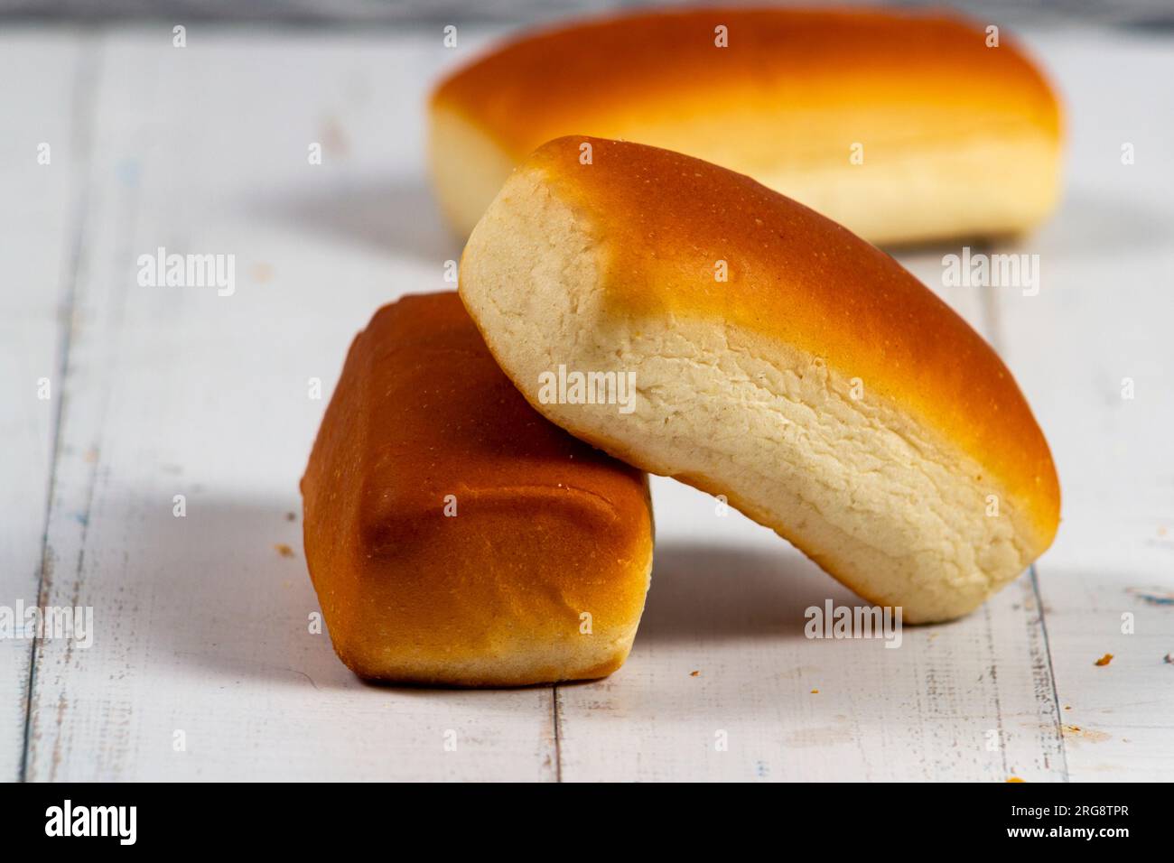 Deux mini pains au Brésil sont appelés «Bisnaguinha» sur une table en bois blanc. Mise au point sélective. Banque D'Images
