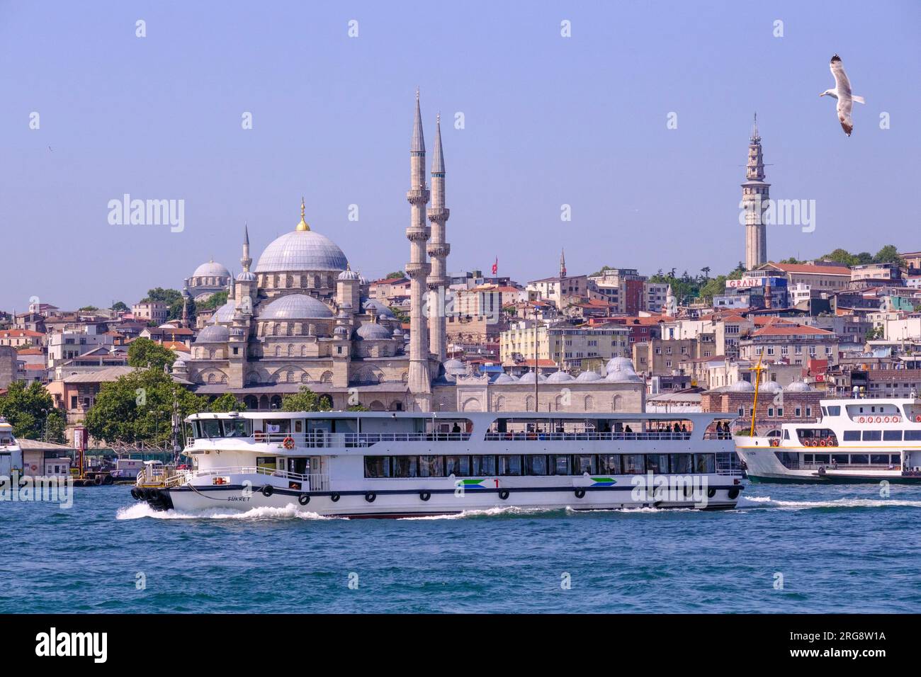 Istanbul, Turquie, Türkiye. Ferry de banlieue naviguant devant la Nouvelle Mosquée (Yeni Camii, terminé en 1663). À l'extrême droite se trouve la tour Beyazıt. Banque D'Images