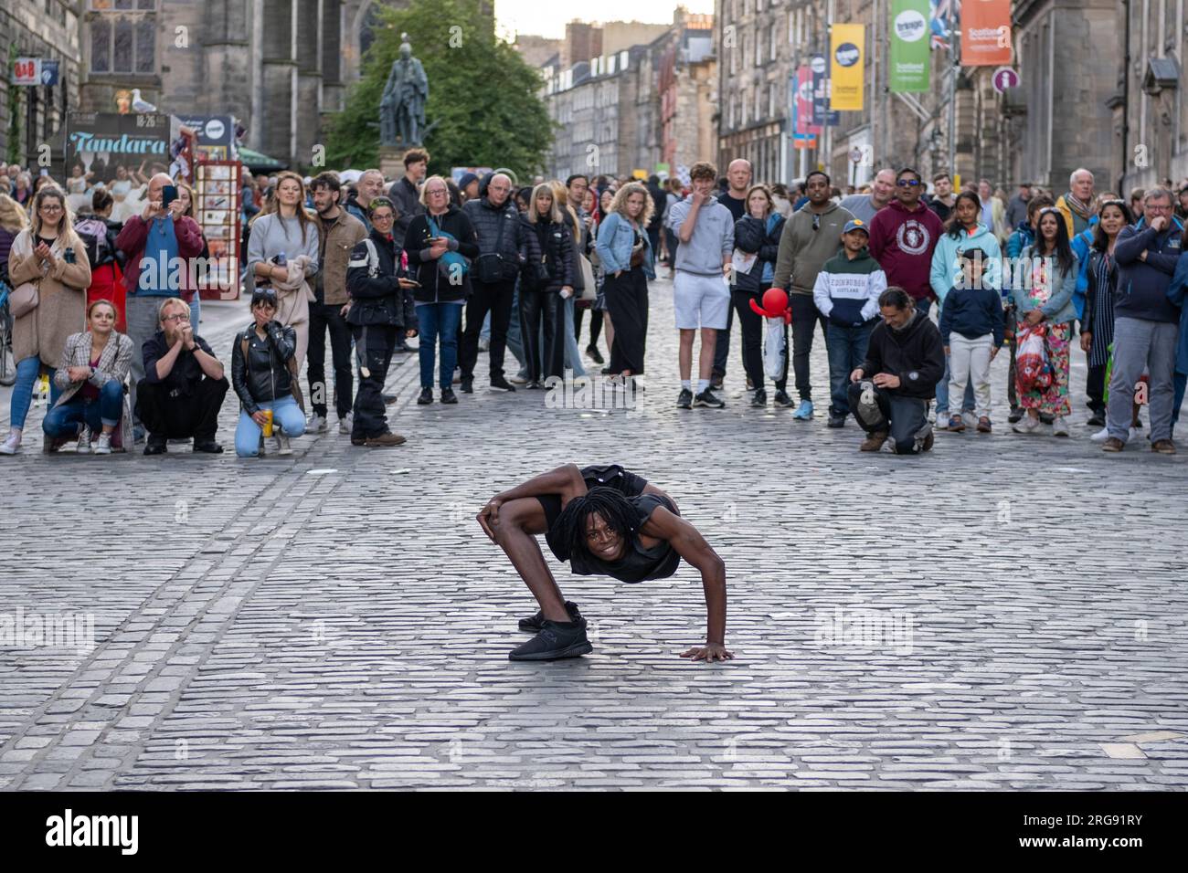 Un membre du groupe guinéen Afrique en Cirque joue un acte de contorsion sur le Royal Mile à Édimbourg pendant le Fringe Festival, août 2023. Écosse. Banque D'Images