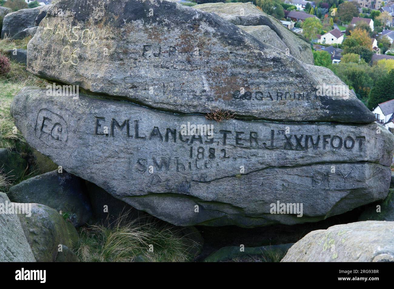 Noms gravés sur des rochers à Ilkley Moor, West Yorkshire. Le nom le plus important est E M Lancaster, 1st XXIV foot, 1882. Banque D'Images