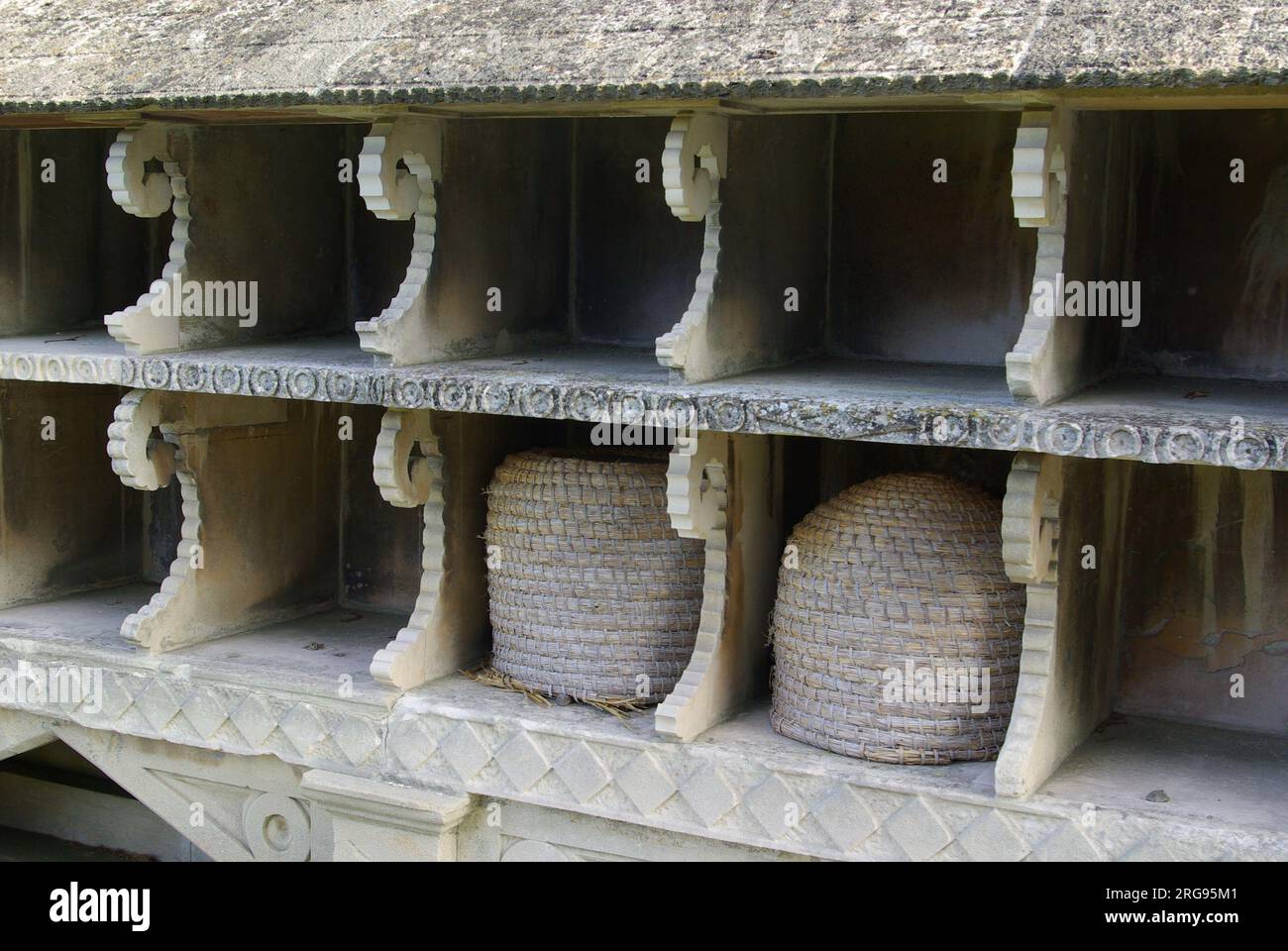 Gros plan d'un abri à abeilles ou d'un casier à ruches datant du milieu du 19e siècle dans le cimetière de l'église St Mary, Hartpury, Gloucestershire. Il est fait de pierre, et dispose de 28 compartiments sur deux niveaux. Il a été déplacé de Nailsworth à Hartpury en 1968 et restauré. Il est inscrit sur le registre des bâtiments classés. Banque D'Images