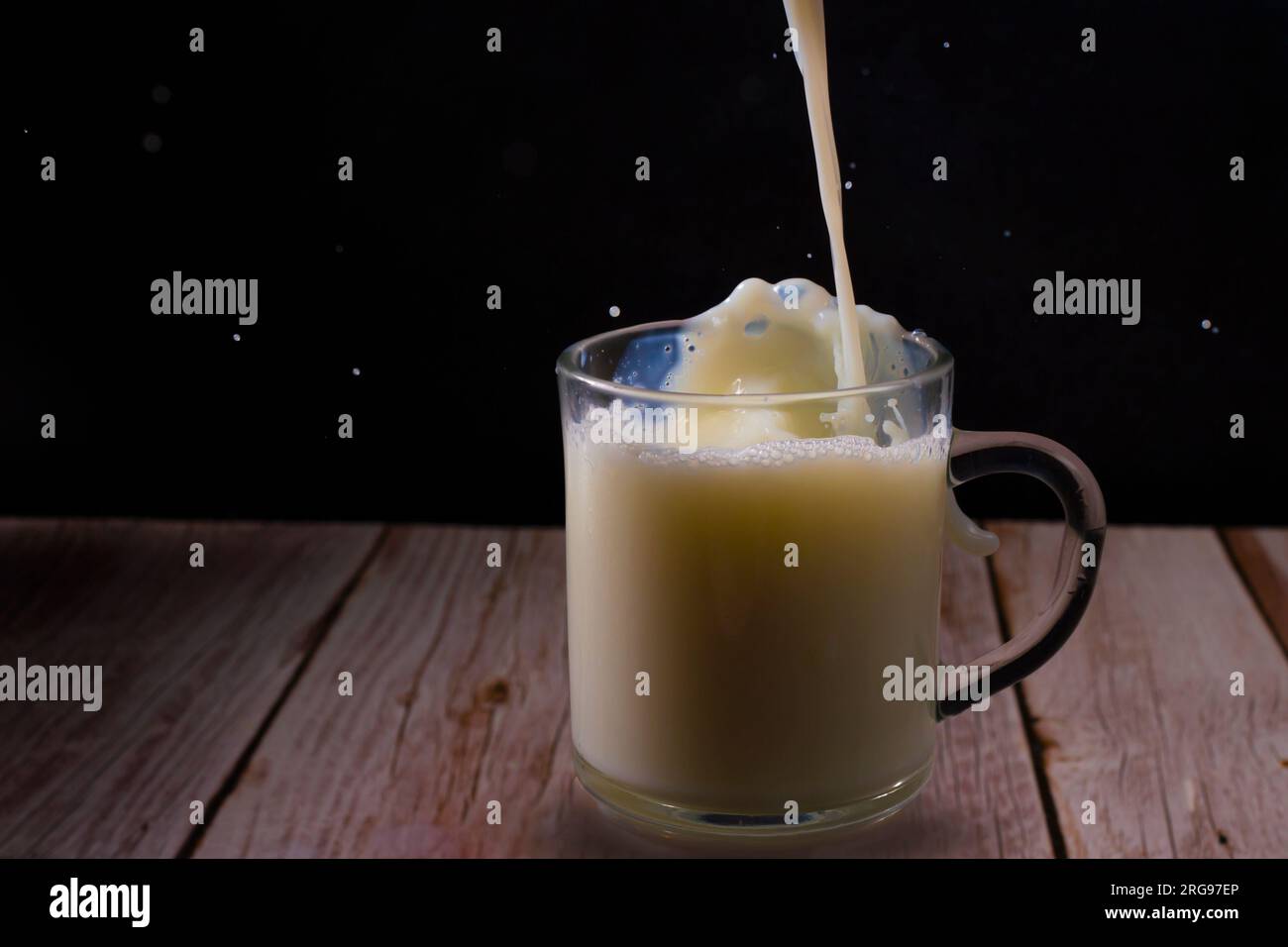 Verser le lait dans une tasse en verre Banque D'Images