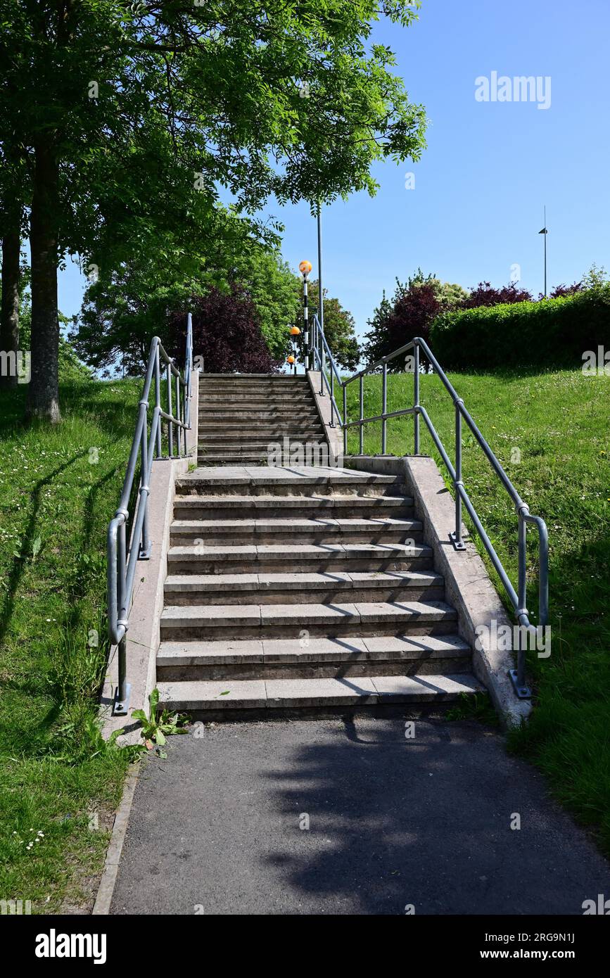 Une double série de marches menant à des balises bélisha à un passage piéton dans un parc de vente au détail. Banque D'Images