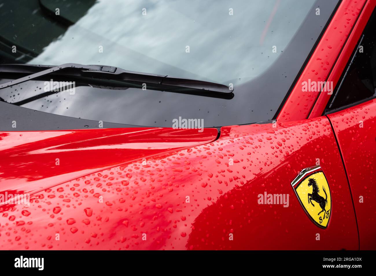 Le logo du panneau latéral Prancing Horse et la section du pare-brise d'une voiture de sport italienne rouge Ferrari F8 Tributo en vue paysage. Banque D'Images