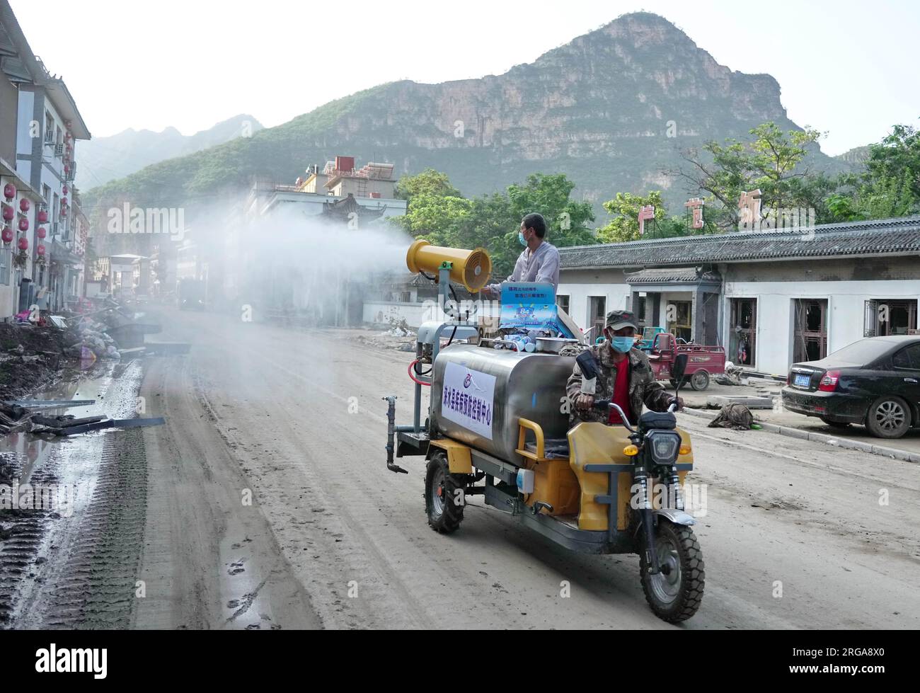 Laishui, province chinoise du Hebei. 8 août 2023. Des volontaires effectuent la désinfection dans le village de Xiazhuang, ville de Sanpo, comté de Laishui, dans la province du Hebei, dans le nord de la Chine, le 8 août 2023. Touché par le typhon Doksuri, le comté de Laishui a récemment subi de fortes pluies et certains villages ont connu des perturbations de la circulation et des communications. Actuellement, les autorités locales réparent les infrastructures endommagées par les inondations pour ramener la vie à la normale dès que possible. Crédit : Yang Shiyao/Xinhua/Alamy Live News Banque D'Images