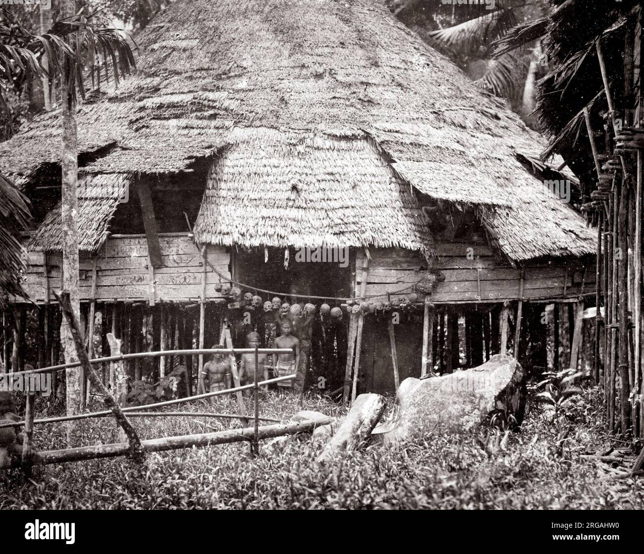 c. 1870s - Indes néerlandaises, Indonésie Sumatra - maison appartenant à des membres d'une tribu de chasse au chef avec des crânes accrochés à l'entrée, probablement la tribu Dayak. Banque D'Images