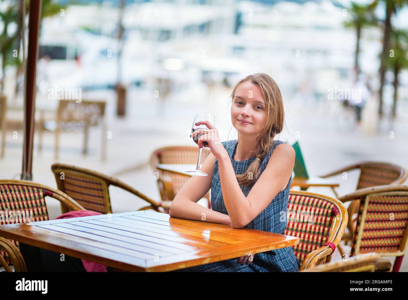 Jeune française buvant du vin rouge dans un café en plein air de Cannes Banque D'Images