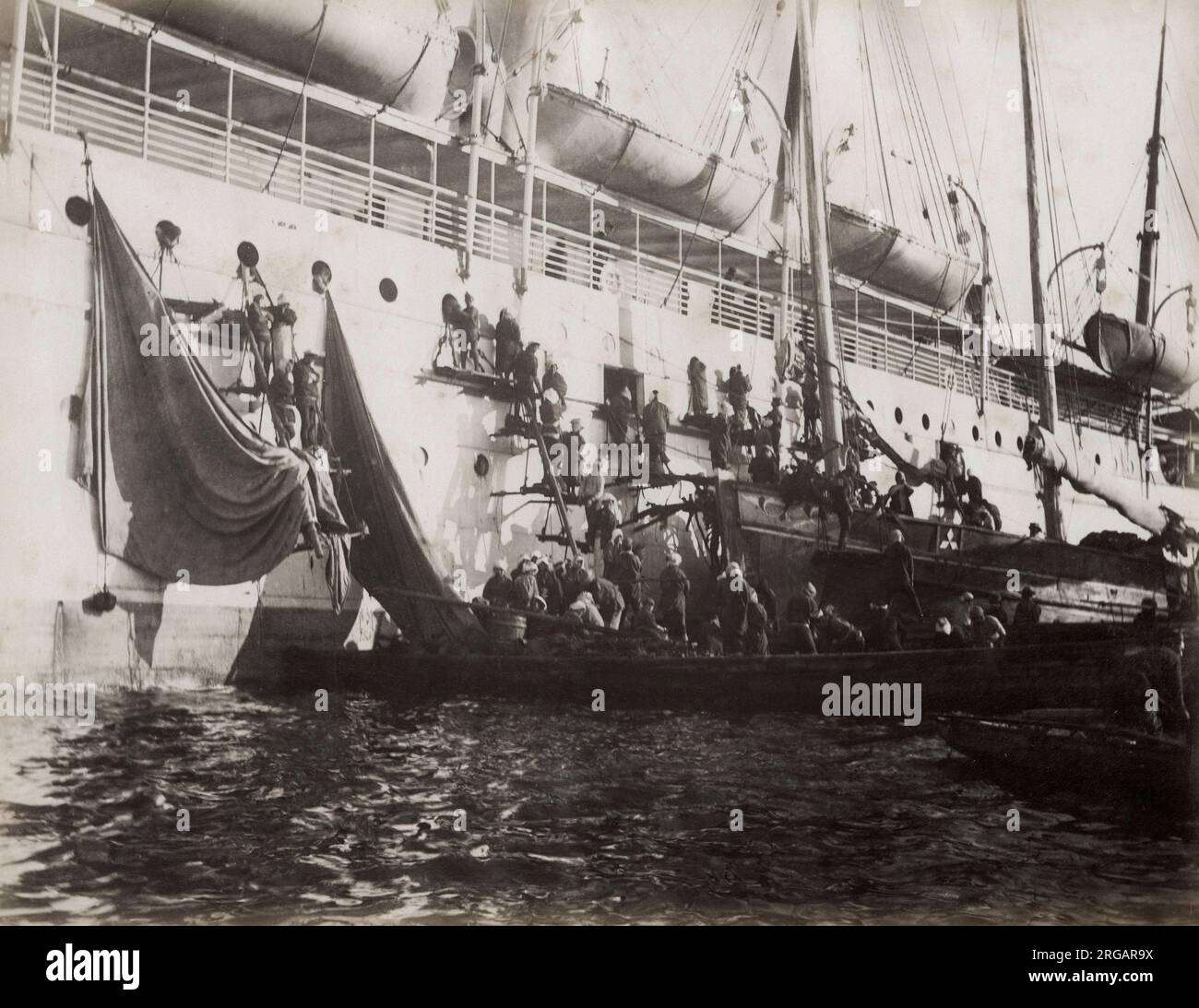 Photographie d'époque du XIXe siècle - les fournitures sont chargées sur un navire de mer, probablement dans un port asiatique, vers 1890. Banque D'Images