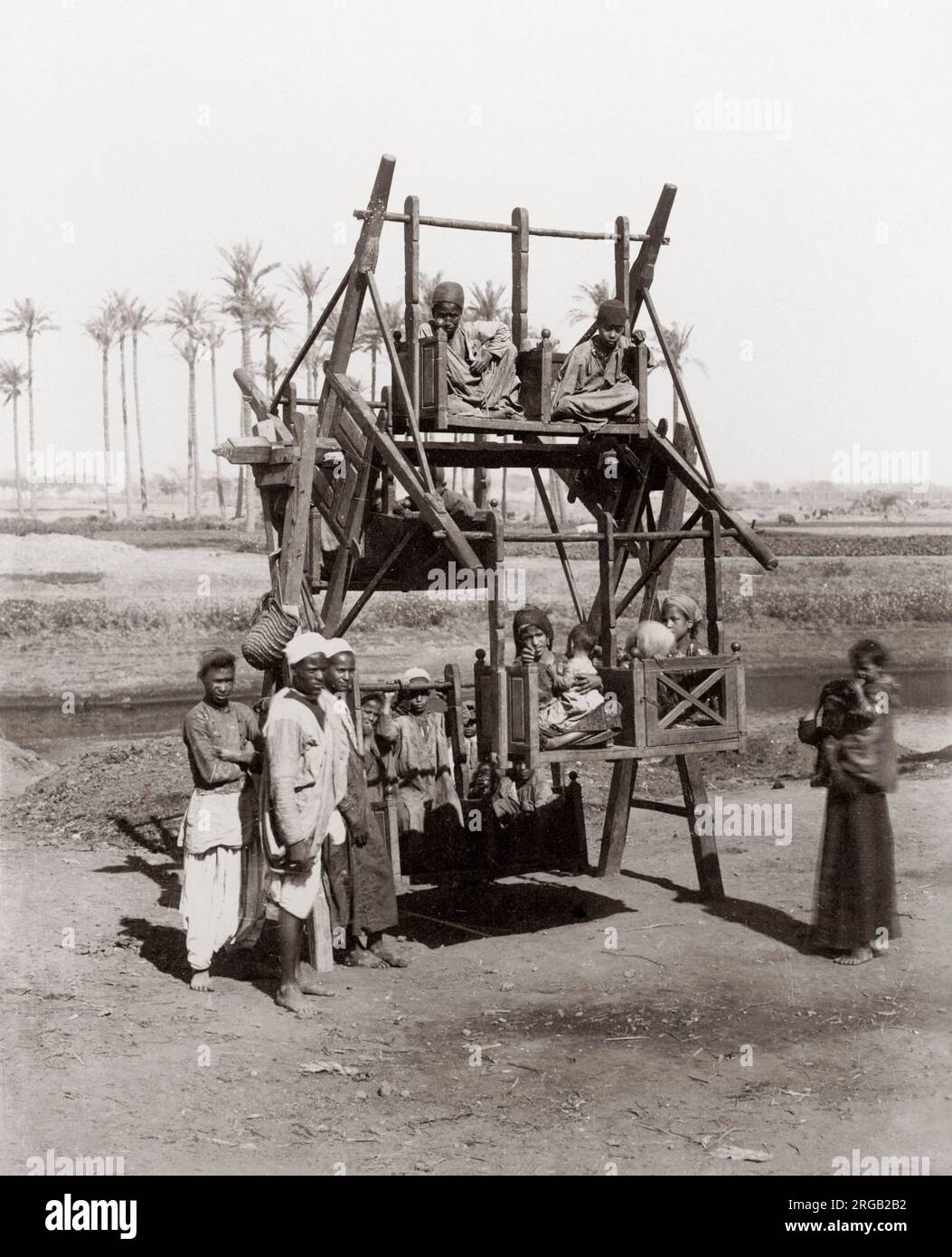 Les enfants lors d'une ancienne fête foraine ride, l'Égypte, c.1890 Banque D'Images