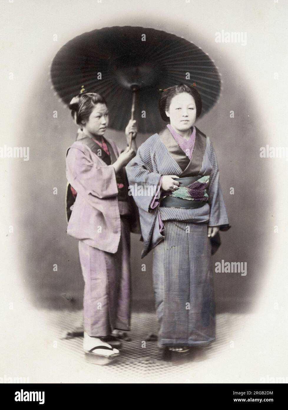 1860's Japon - Portrait de deux jeunes femmes et un parasol Felice ou Felix Beato (1832 - 29 janvier 1909), photographe italien-britannique travaillant principalement en Inde, au Japon, en Chine Banque D'Images