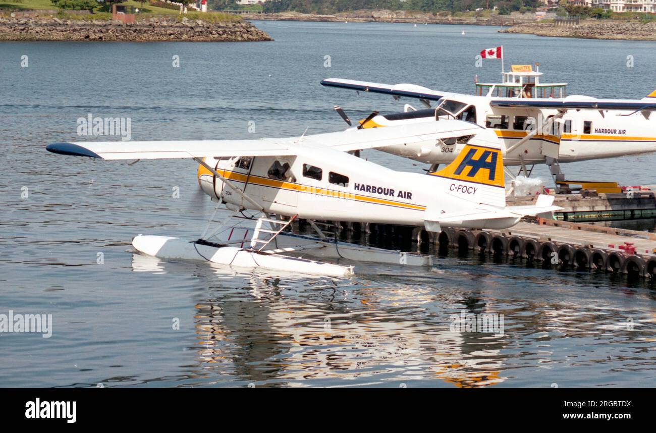 De Havilland Canada DHC-2 Beaver Mk.1 C-FOCY / 204 (msn 79), de Harbour Air, taxant dans le port de Victoria (Colombie-Britannique), passé Harbour Air Turbo-Otter '304'. Banque D'Images