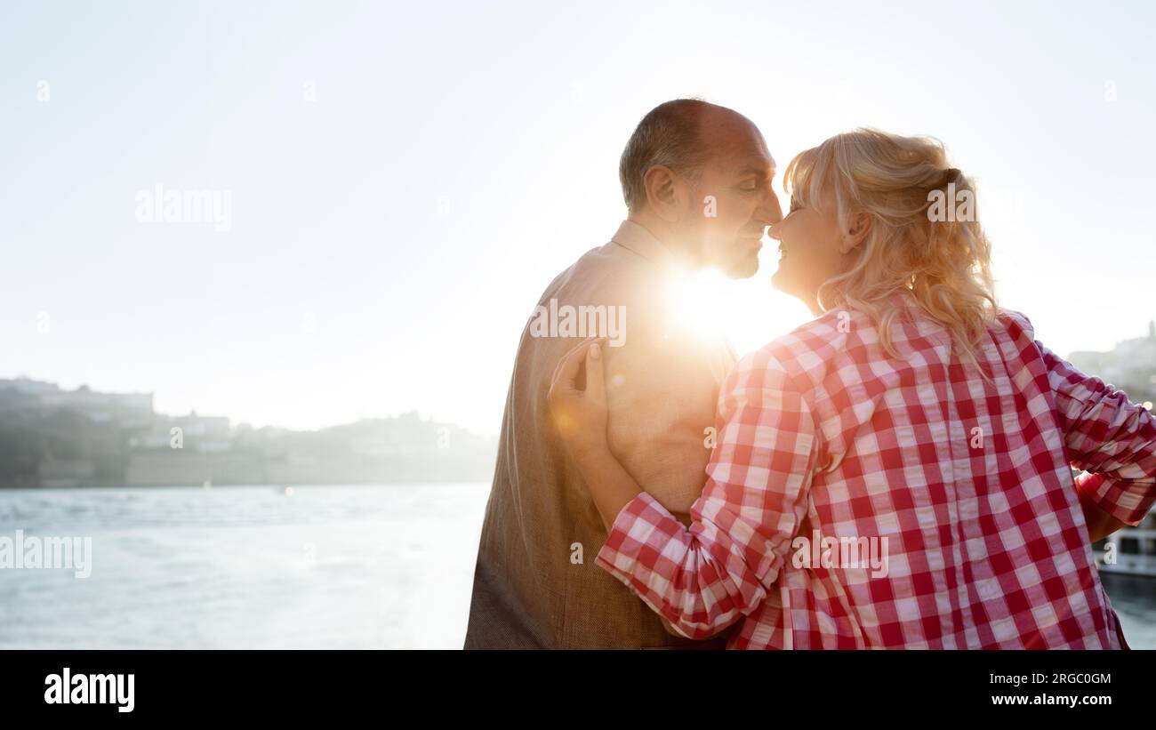 Histoire d'amour mature. Couple senior romantique s'embrassant à l'extérieur au coucher du soleil Banque D'Images
