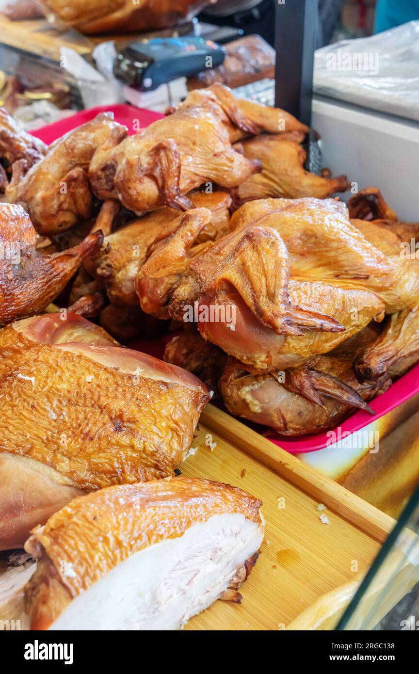 Du poulet fumé et d'autres délices fermiers se trouvent sur le comptoir. Les produits carnés sont prêts à être vendus à la foire. Banque D'Images