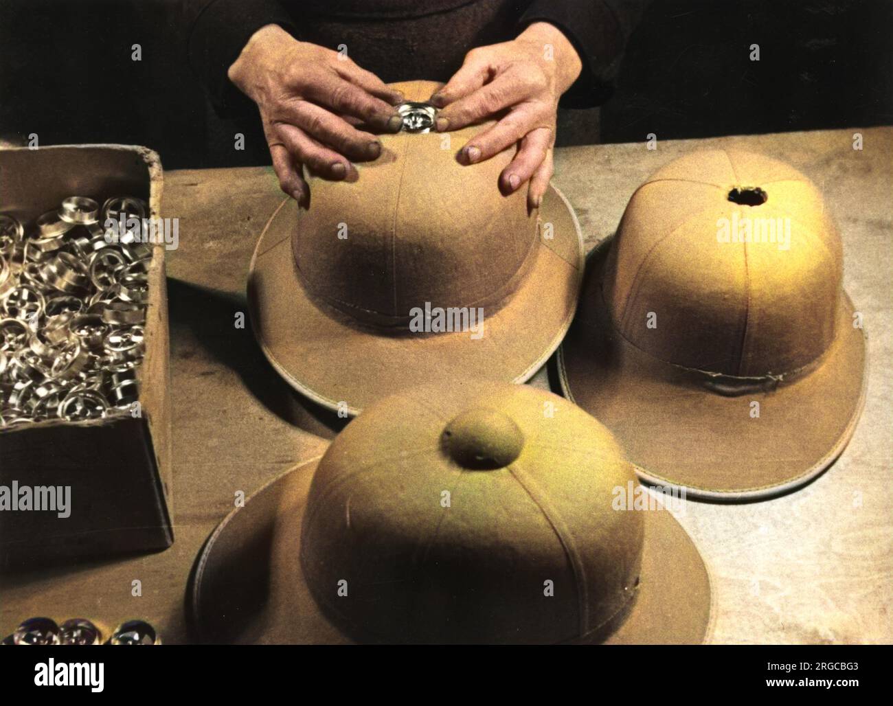 Fabrication de casques de type I pour l'Afrika Korps allemande - Seconde Guerre mondiale. Insertion du capuchon de ventilation sur le dessus du casque. Banque D'Images