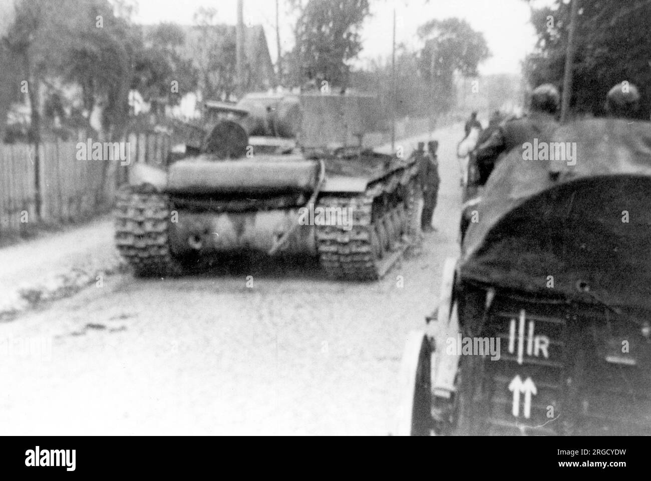 Un char lourd soviétique 'KV-1', frappé par un feu anti-char allemand, avec un camion Wehrmacht tiré par des chevaux le passant. (Les chars Kliment Voroshilov (KV) sont une série de chars lourds soviétiques nommés d'après le commissaire de la défense soviétique et le politicien Kliment Voroshilov) Banque D'Images