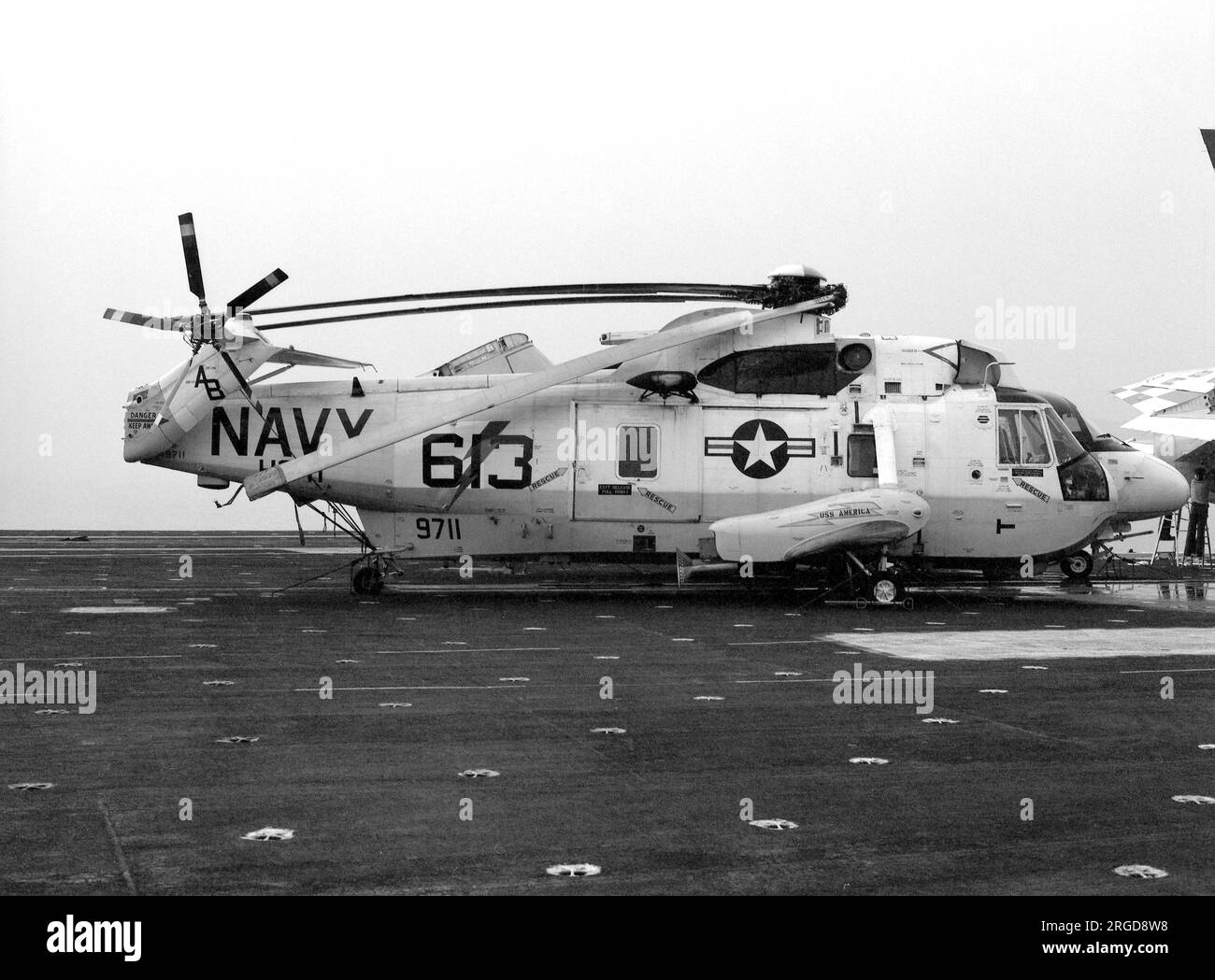 Marine des États-Unis - Sikorsky SH-3H Sea King 149711 (msn 61128, code de base AB, indicatif d'appel 613), du HS-11 embarqué sur l'USS America le 18 septembre 1982. Vu range sur le pont plié, prêt pour le hangar. Banque D'Images