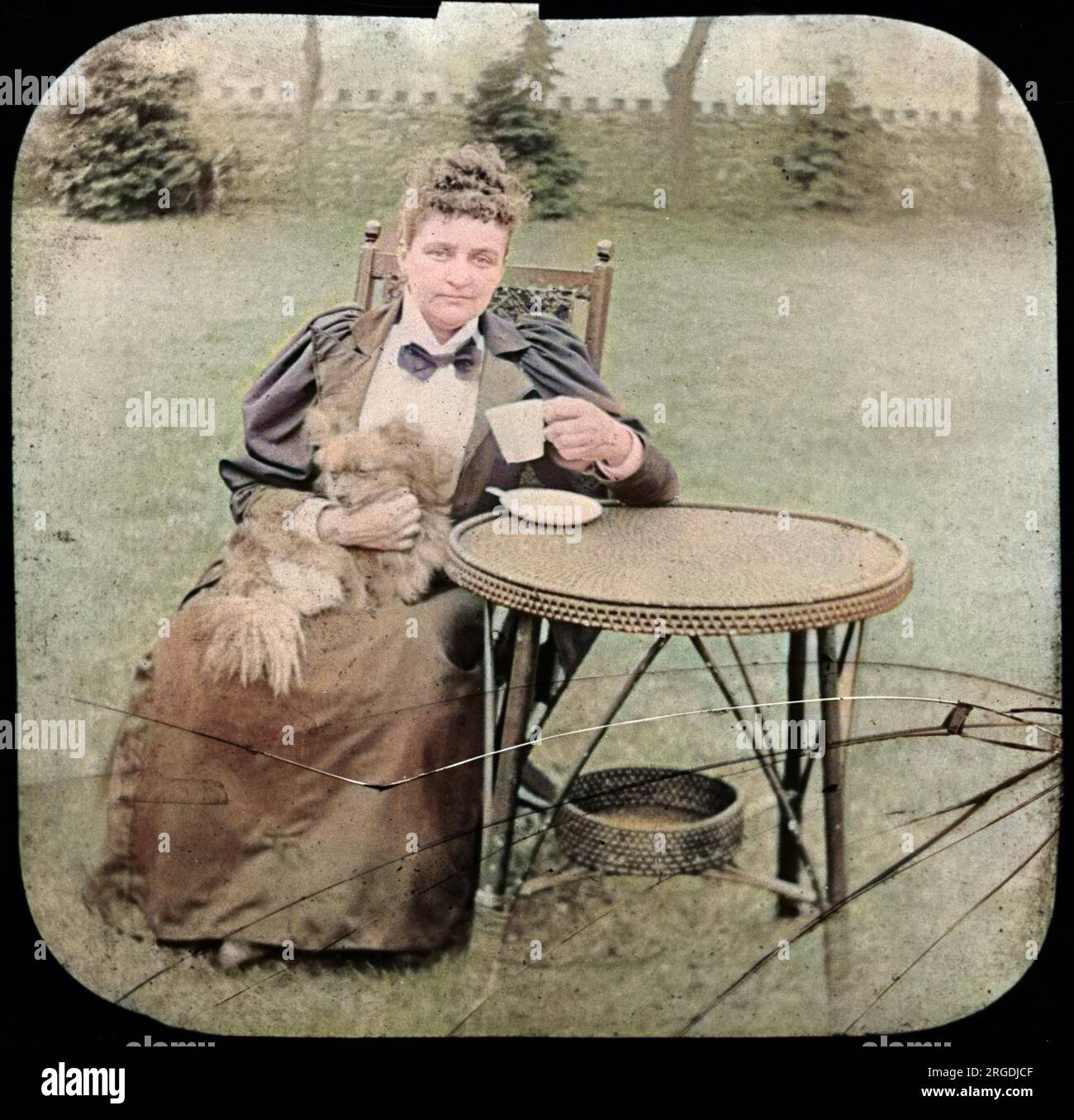 Florence Cook (c.1856-1904) était un médium anglais qui prétendait matérialiser un esprit nommé Katie King. Vu ici plus tard, assis dans un jardin avec un chien sur ses genoux. Banque D'Images