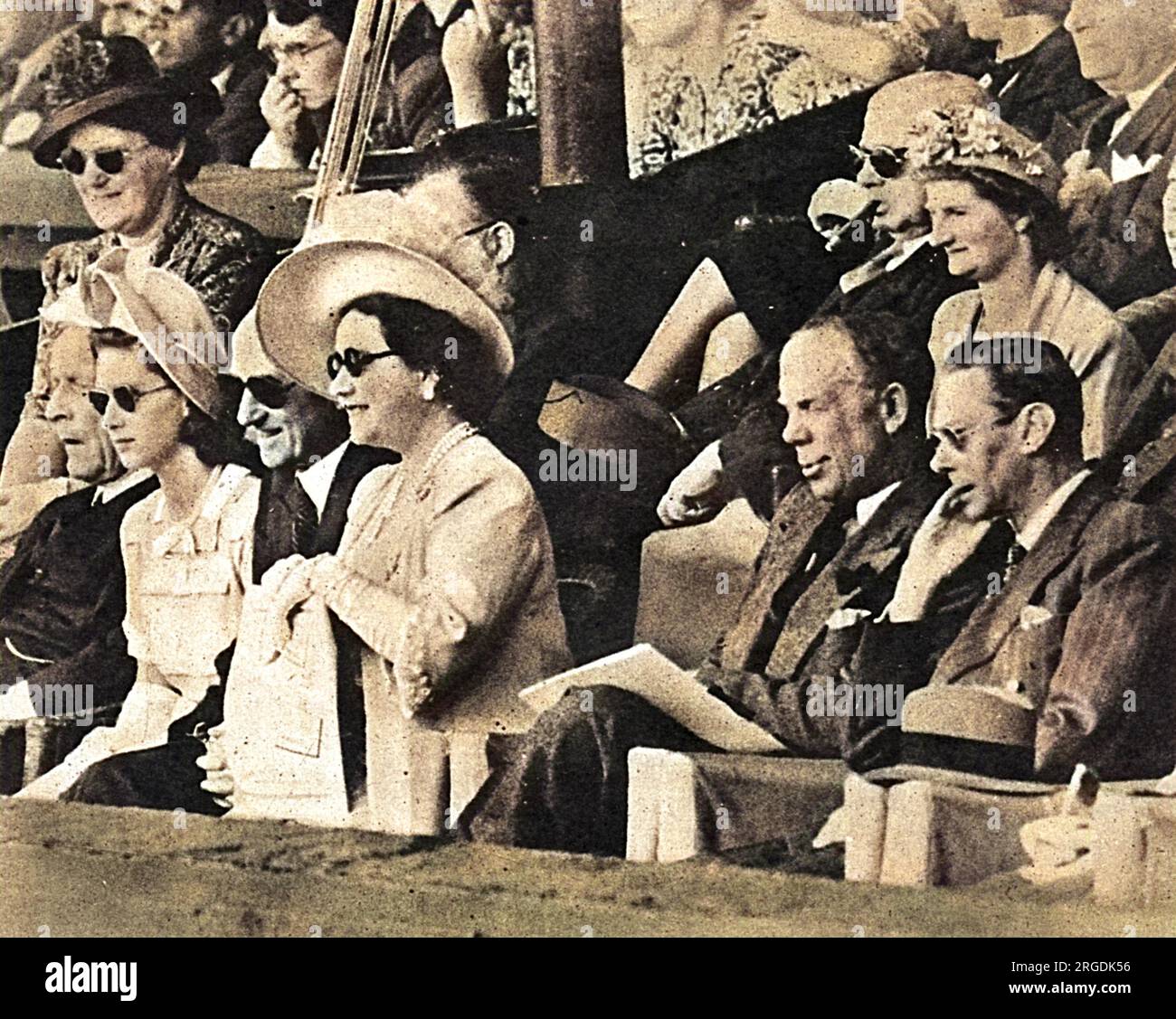 Captivés par le jeu, la princesse Margaret, la reine Elizabeth, Sir Louis Greig et le roi George VI à Wimbledon. Il s'agissait de la première visite du roi George depuis qu'il concourait dans le double masculin avec Sir Louis Greig. Banque D'Images