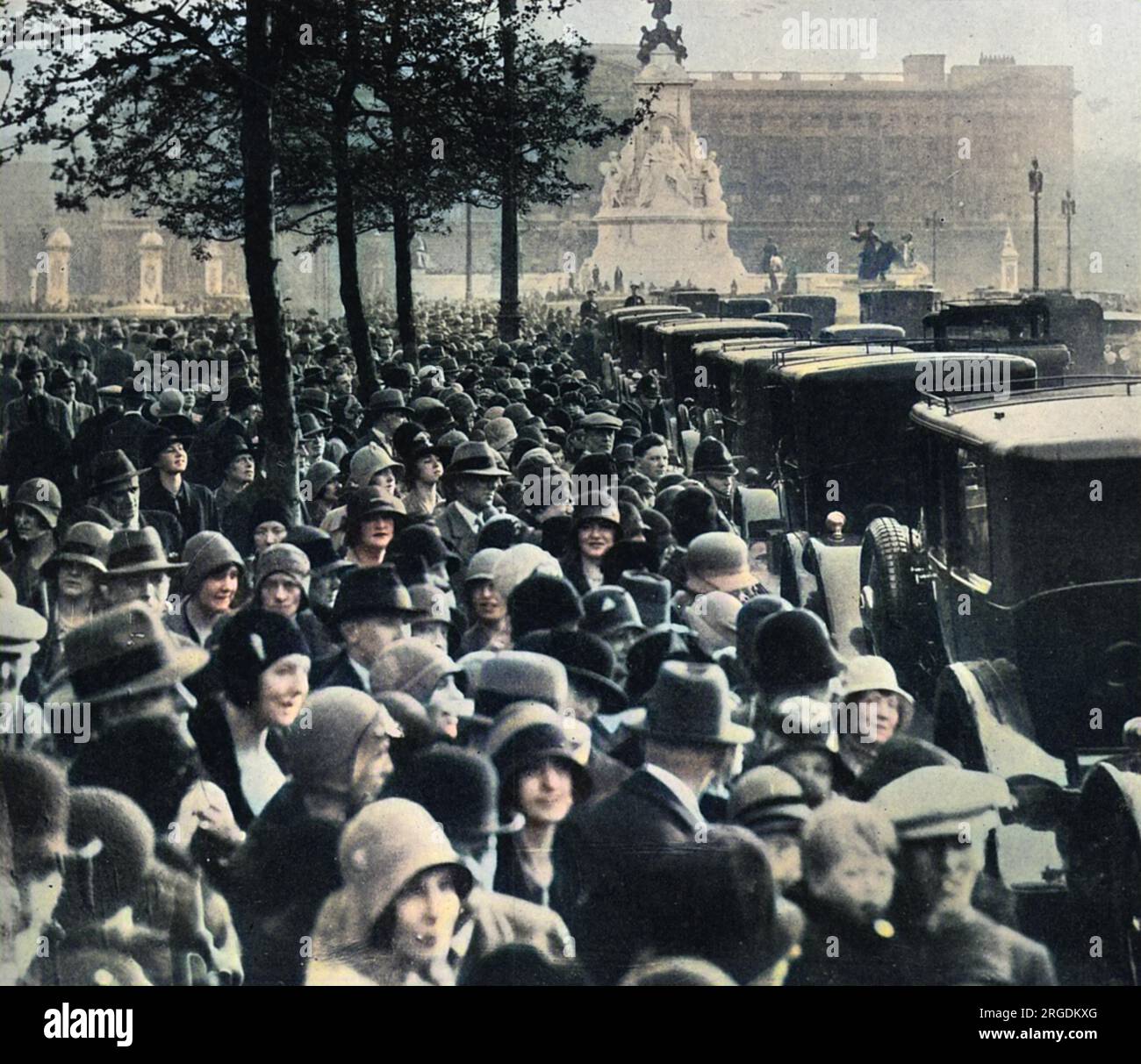 Une vue familière dans le centre de Londres pendant la saison - une longue file de voitures s'accrochant jusqu'au Mall vers Buckingham Palace. À l'intérieur sont des débutantes et d'autres dames qui doivent être présentées à la cour, tous venant sous l'examen de la foule qui se rassemble pour regarder. Banque D'Images