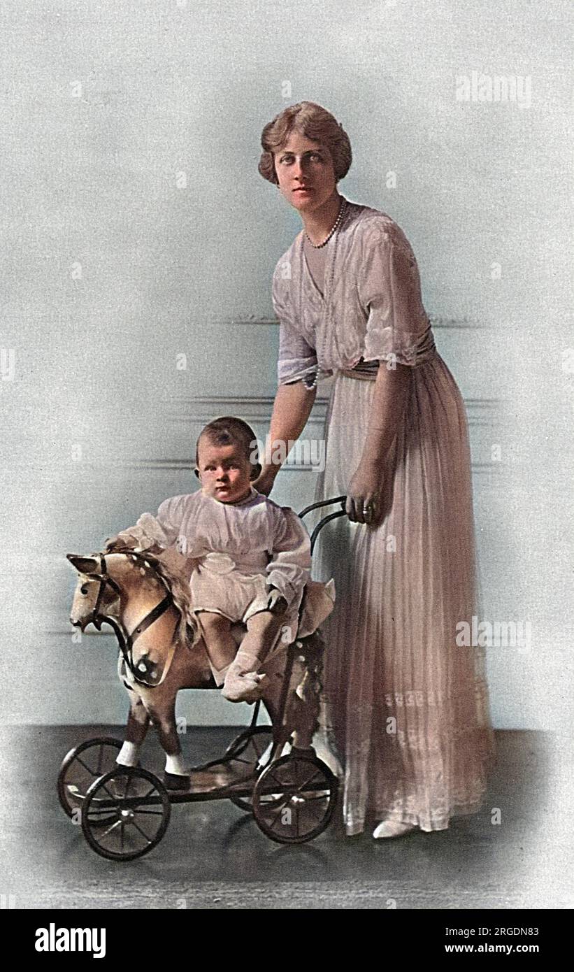 Alexandra, duchesse de Fife (1891-1959) avec son fils unique, Alastair Arthur, comte de Macduff, 2e duc de Connaught (1914-1943). Alexandra était la fille aînée de la princesse Louise de Galles, duchesse de Fife ; après la mort de son père à Assouan en 1912, elle a été autorisée à hériter du duché de Fife à part entière. Elle était généralement connue sous le nom de princesse Arthur de Connaught après son mariage avec son cousin, le prince Arthur de Connaught. Bébé Alastair est assis sur un cheval jouet pousse-a-long plutôt gentil à roues. Banque D'Images