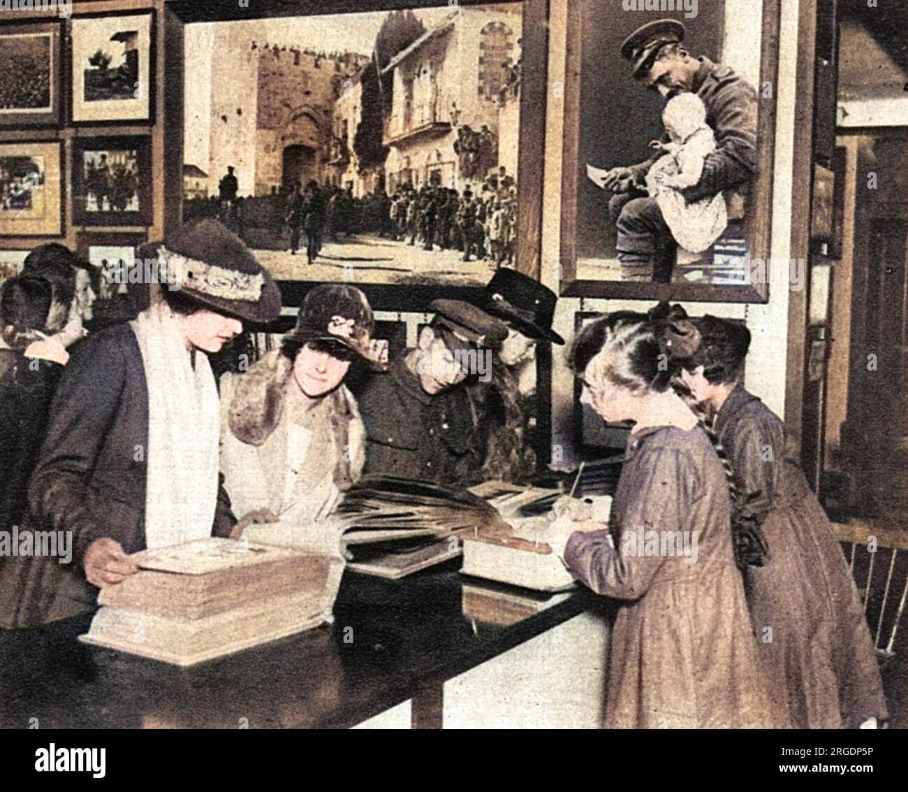 Clients inspectant des albums photos dans un nouveau bureau de vente de photographies de guerre officielles ouvert par le ministère de l'information à Coventry Street par John Buchan en octobre 1918. Banque D'Images