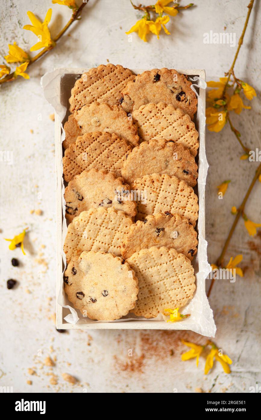 Une boîte de biscuits Shrewsbury entourée de fleurs jaunes Banque D'Images