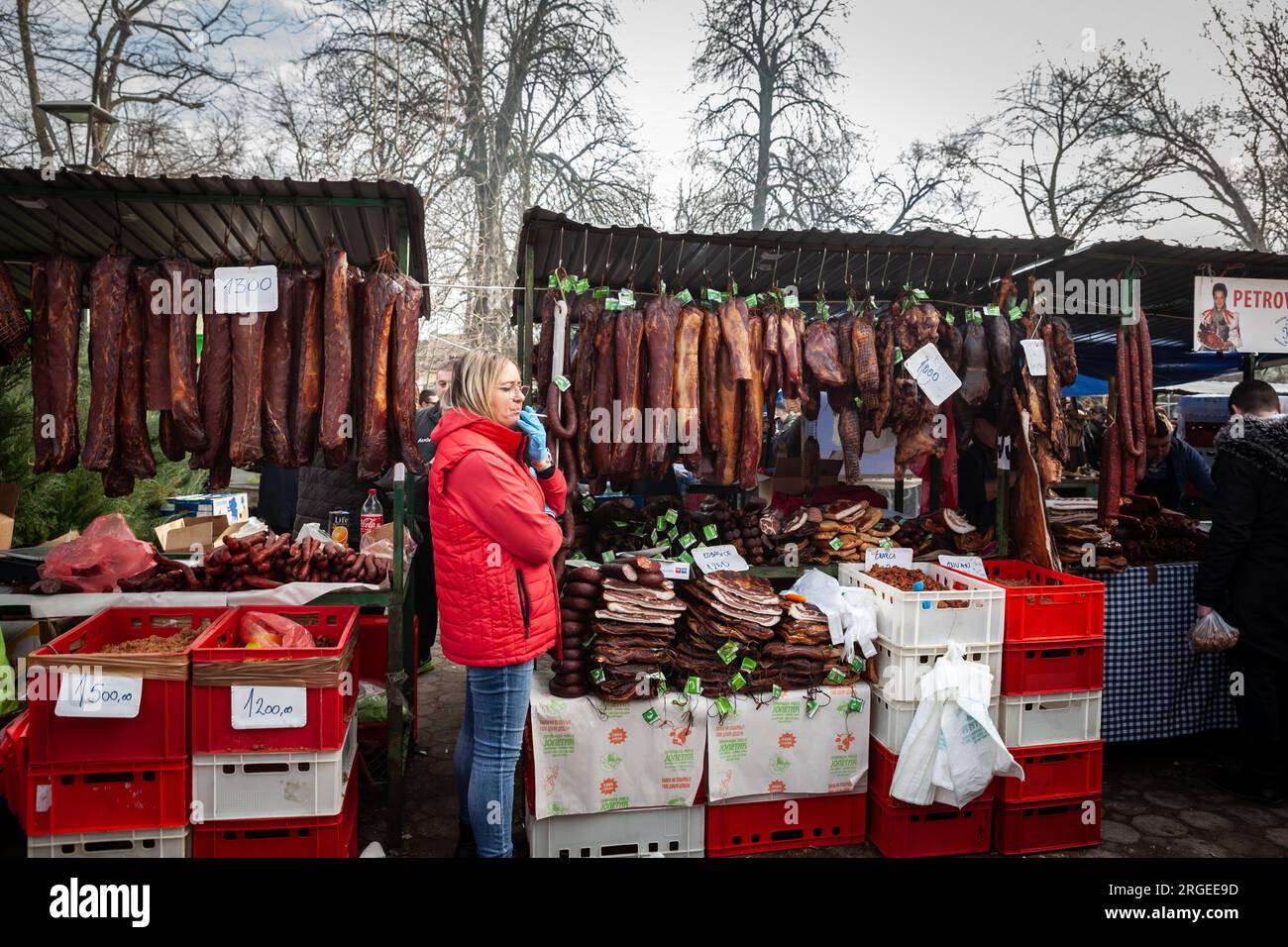 Photo d'un stand du marché de Kacarevo en Serbie, avec la viande séchée pendante et séchée, comme le jambon et les saucisses et la viande séchée appelée suvo meso. Banque D'Images